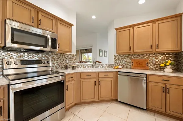 a kitchen with white cabinets appliances and sink
