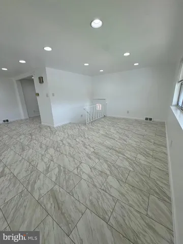 a large kitchen with kitchen island granite countertop a sink and white cabinets