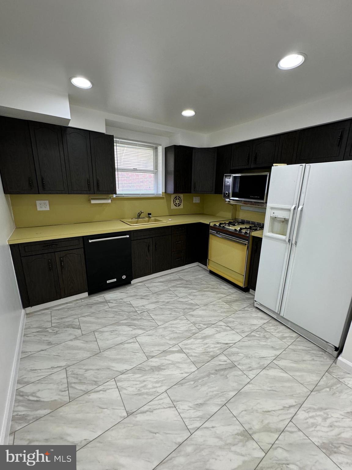 2327 Hoffnagle Street, Unit 2 Philadelphia, PA 19152 - Photo 5 of 19 a large kitchen with kitchen island granite countertop a sink and white cabinets