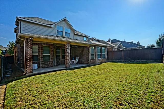 a view of house with swimming pool and a yard