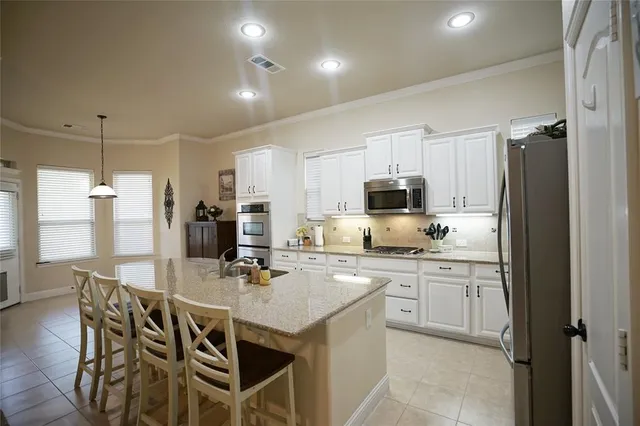 a kitchen with stainless steel appliances granite countertop a stove refrigerator and cabinets