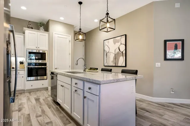 a kitchen with a refrigerator a sink and dishwasher a oven with wooden floor