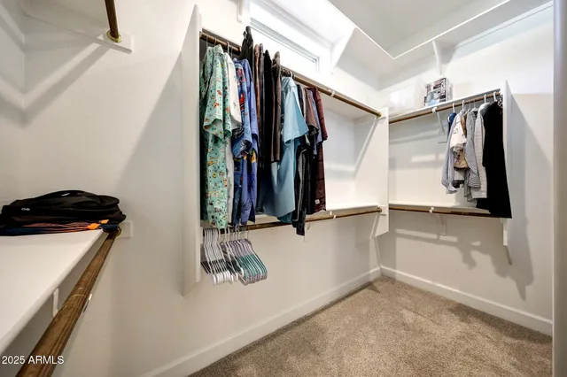 a view of walk in closet with clothes and shoes
