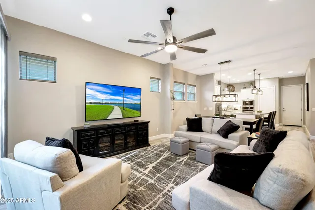 a living room with furniture a ceiling fan and a window