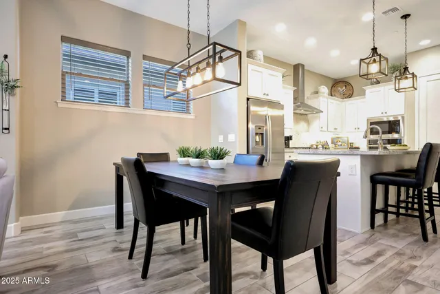 a kitchen with a dining table chairs and cabinets