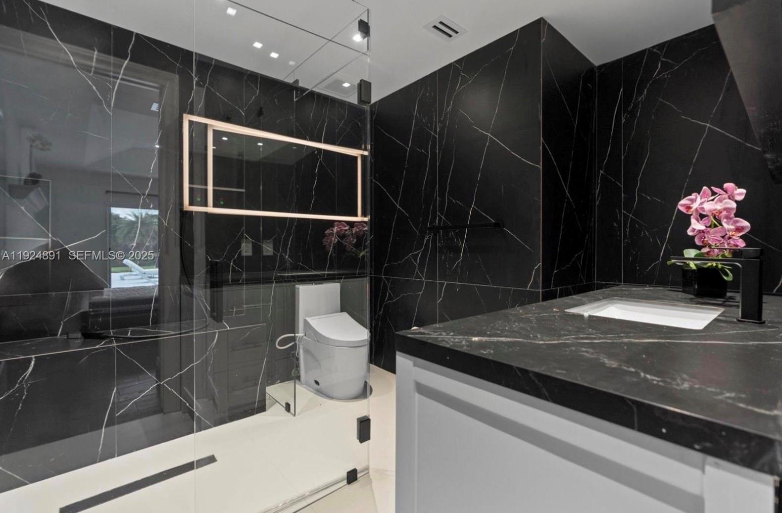 17873 Fieldbrook Circle East Boca Raton, FL 33496 - Photo 19 of 26 a bathroom with a granite countertop sink a toilet and shower