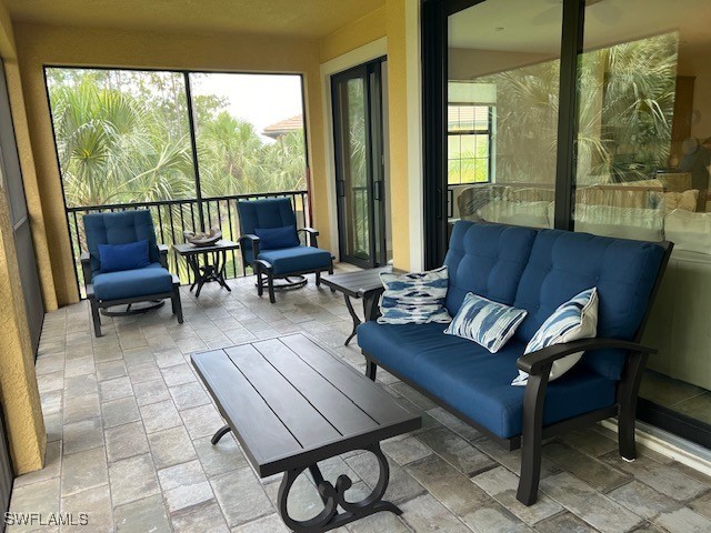 10455 Casella Way, Unit 202 Fort Myers, FL 33913 - Photo 28 of 41 a living room with furniture and a floor to ceiling window