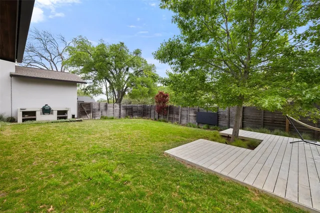 a view of a backyard with couches plants and large tree