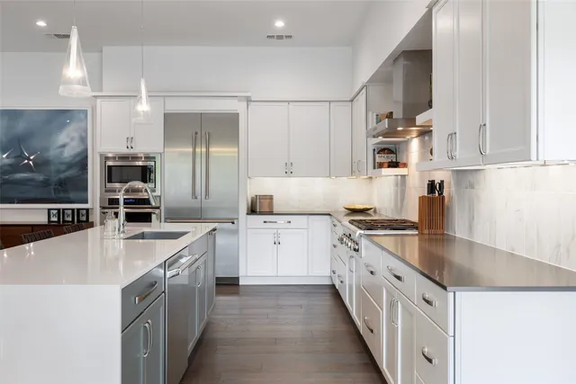 a kitchen with stainless steel appliances granite countertop a sink and a stove
