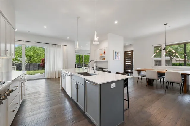 a kitchen with a sink and chairs