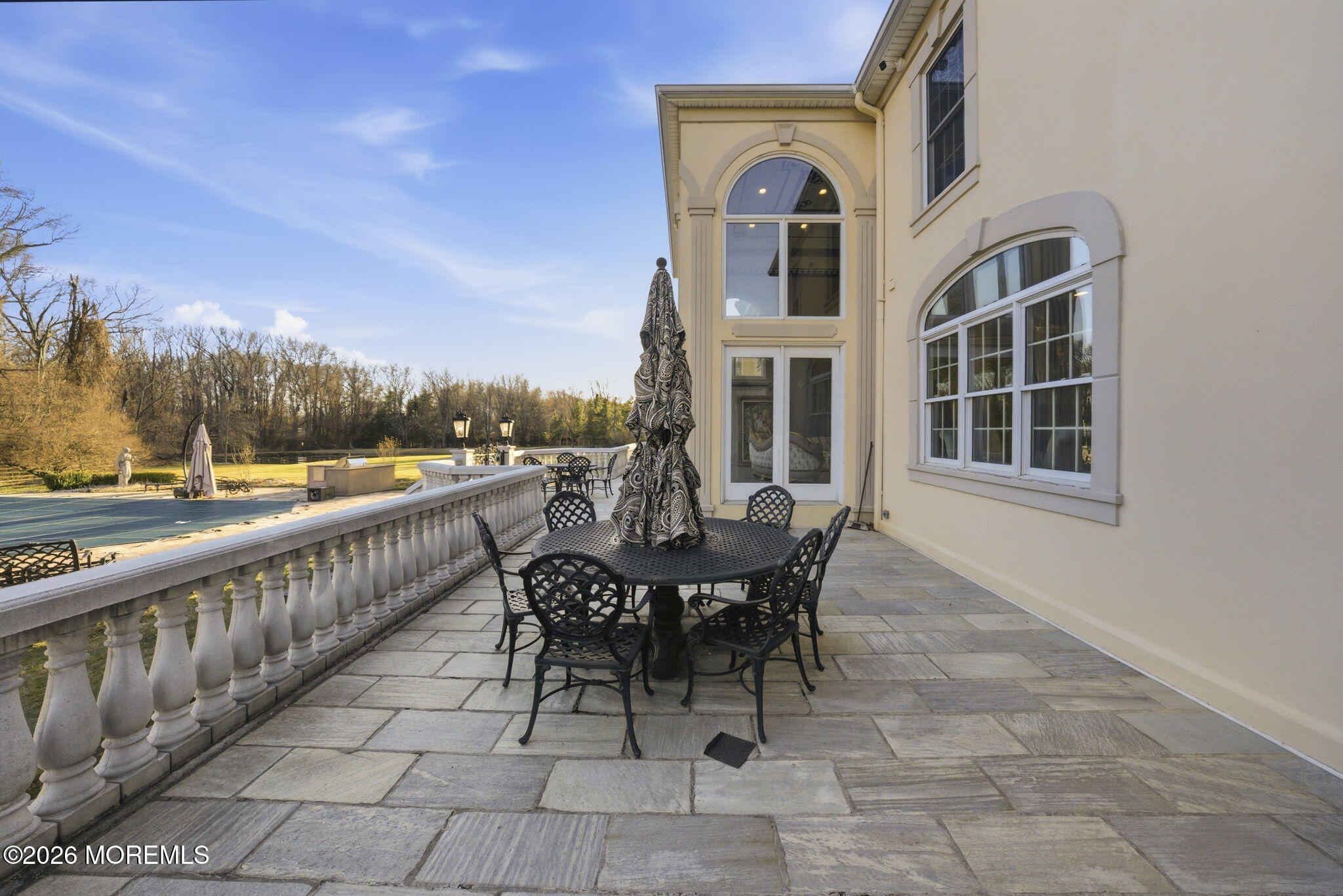 4 Squan Song Lane Colts Neck, NJ 07722 - Photo 35 of 45 a view of a patio with table and chairs and floor to ceiling window