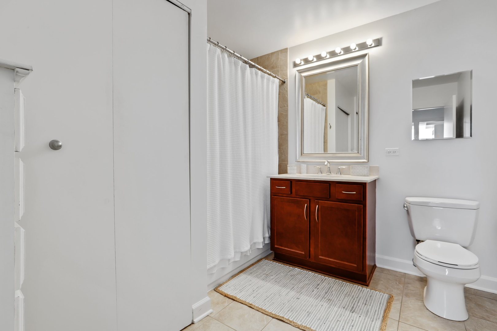 100 East 14th Street, Unit 1908 Chicago, IL 60605 - Photo 13 of 20 a bathroom with a toilet a sink and mirror