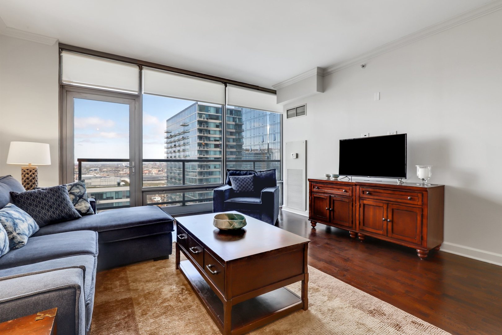 100 East 14th Street, Unit 1908 Chicago, IL 60605 - Photo 3 of 20 a living room with furniture and a flat screen tv