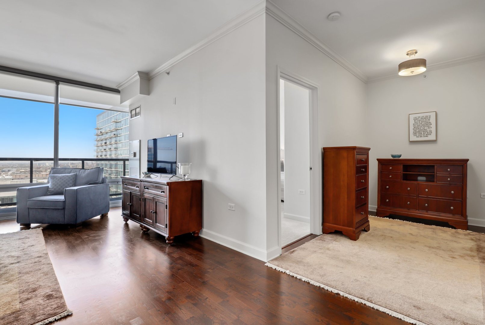 100 East 14th Street, Unit 1908 Chicago, IL 60605 - Photo 8 of 20 a living room with furniture and a flat screen tv