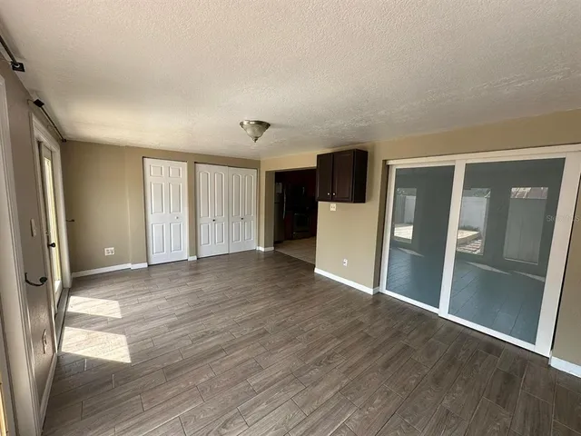 a view of a big room with wooden floor and windows