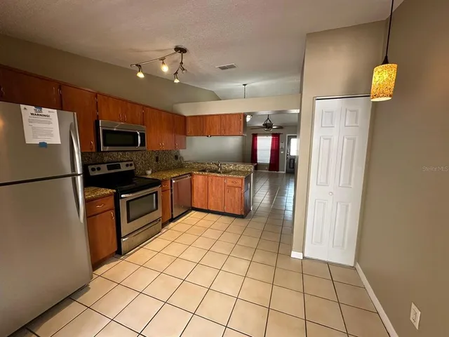 a kitchen with stainless steel appliances granite countertop a refrigerator and a sink