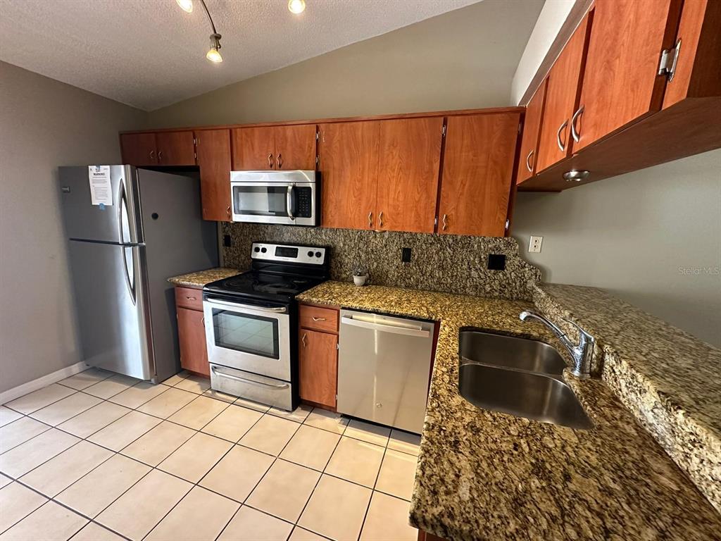 1715 Oak Branch Court, Unit 1715 Brandon, FL 33511 - Photo 6 of 15 a kitchen with stainless steel appliances granite countertop a refrigerator stove and sink