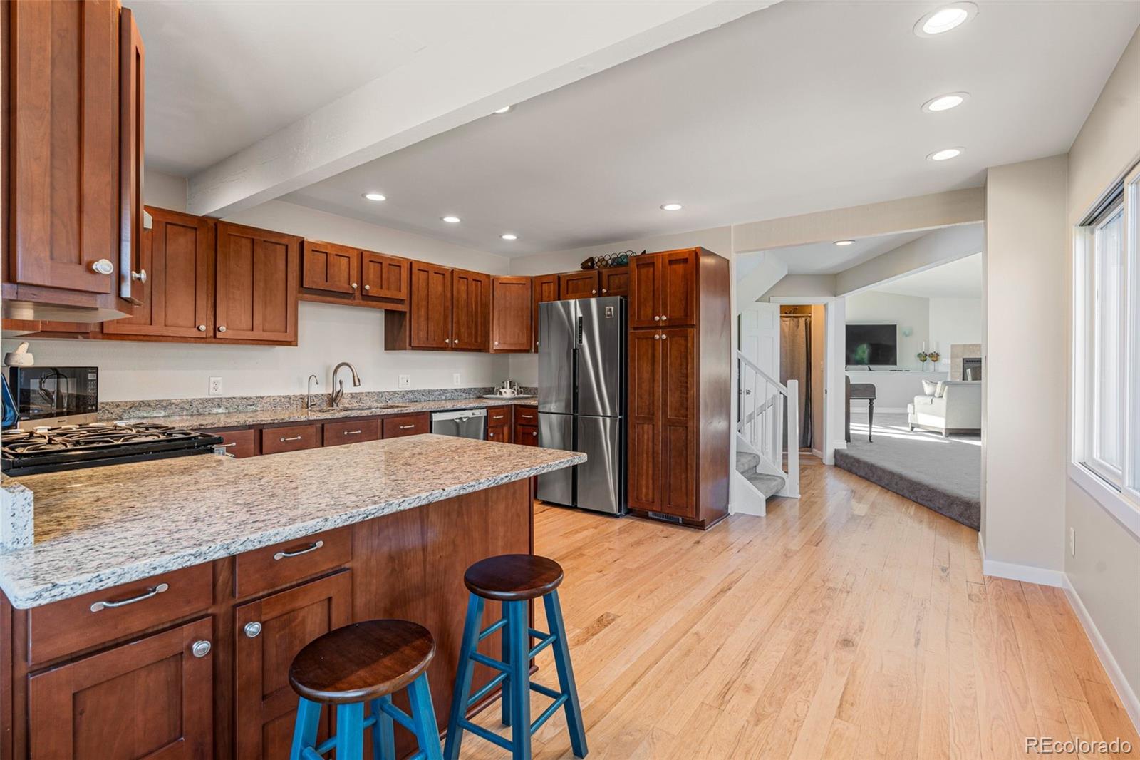319 Camino Bosque Boulder, CO 80302 - Photo 10 of 44 a kitchen with stainless steel appliances granite countertop a refrigerator a sink dishwasher a stove and white countertops with wooden floor