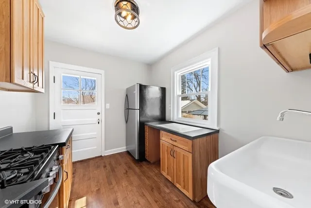 a kitchen with stainless steel appliances a refrigerator a stove a sink and a window