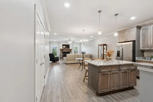 a kitchen with stainless steel appliances a white table chairs refrigerator and microwave