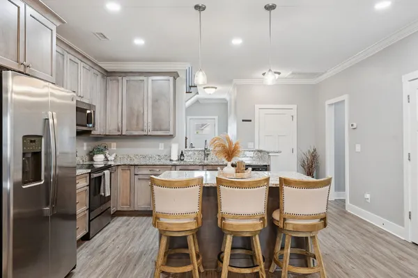 a kitchen with kitchen island granite countertop a sink stove and refrigerator