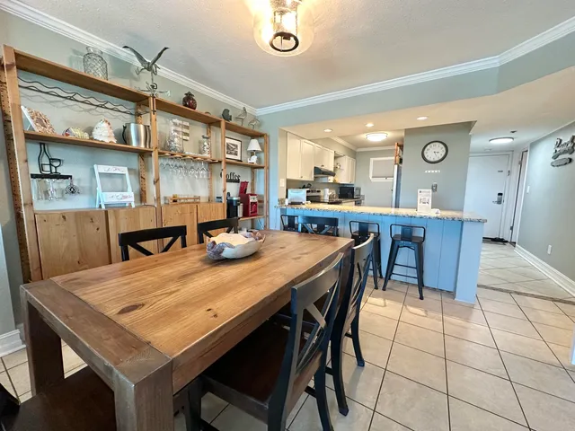 a room with stainless steel appliances kitchen island a table and chairs in it