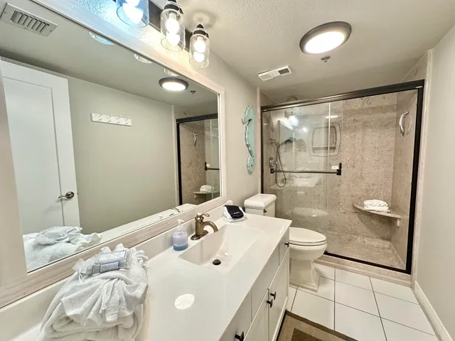 a spacious bathroom with a shower sink mirror and toilet