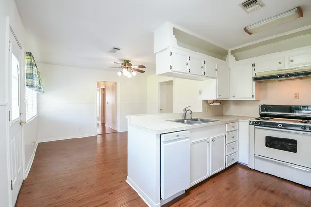 a kitchen with stainless steel appliances granite countertop a sink a stove and cabinets