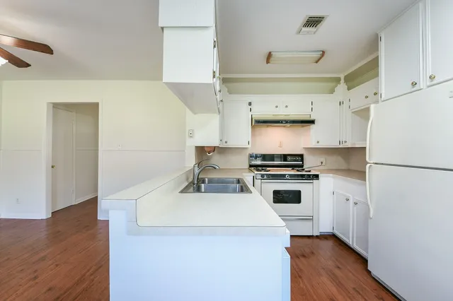 a kitchen with a refrigerator and a stove top oven