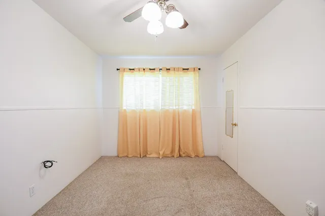 a view of a livingroom with furniture and a ceiling fan