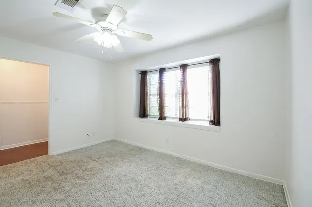 a view of a kitchen with wooden floor and a ceiling fan