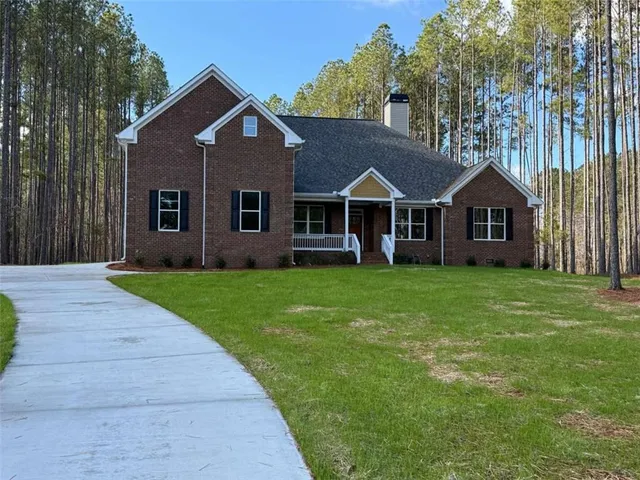 a front view of a house with a garden and trees