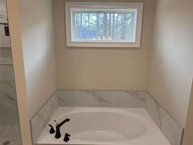 an empty room with a chandelier fan and windows