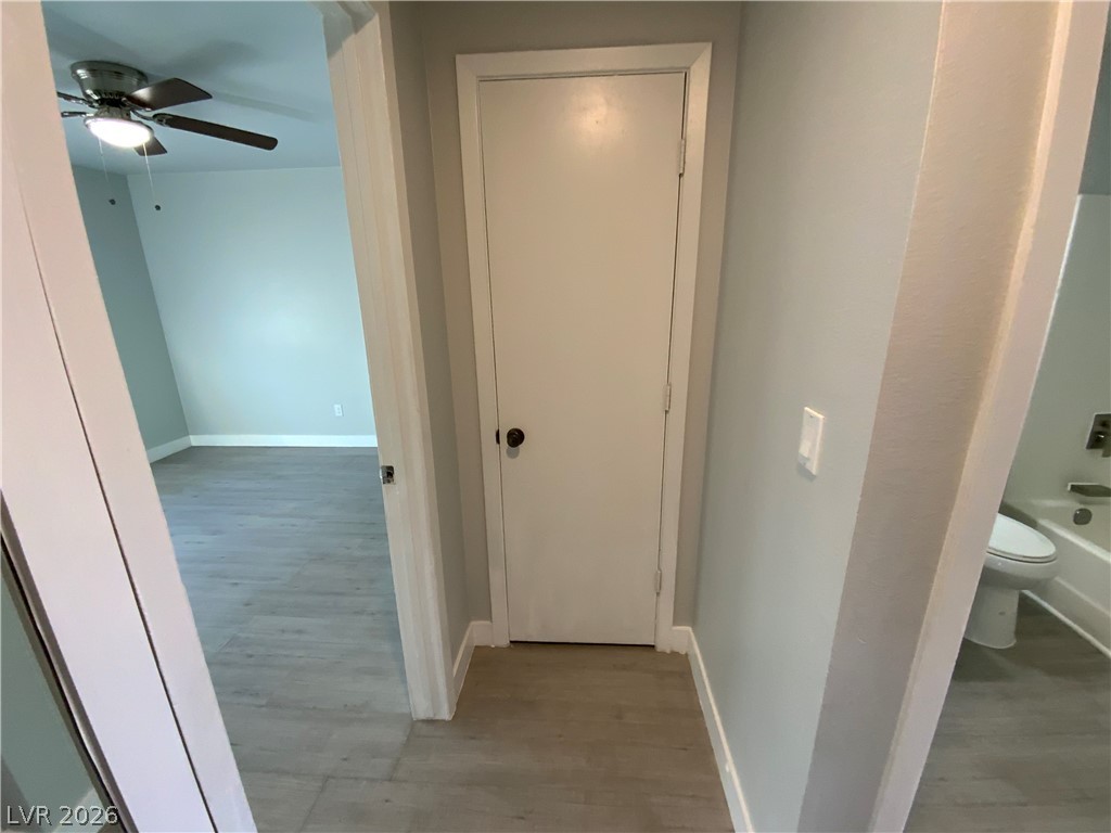 466 East Sunset Road, Unit C Henderson, NV 89011 - Photo 9 of 12 Hallway featuring wood finished floors and baseboards