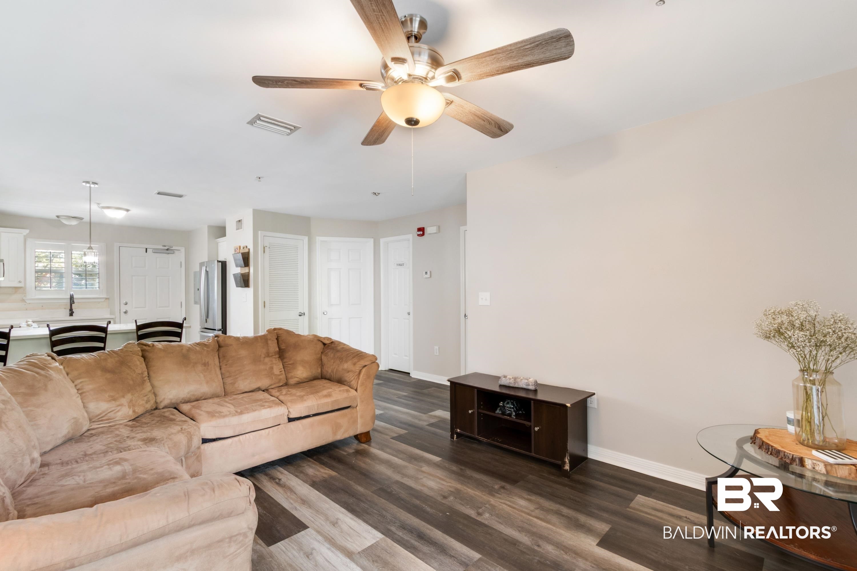 25957 Canal Road, Unit 208 Orange Beach, AL 36561 - Photo 5 of 28 Open concept living area featuring wood-finish flooring, a ceiling fan with integrated lighting, and neutral wall tones