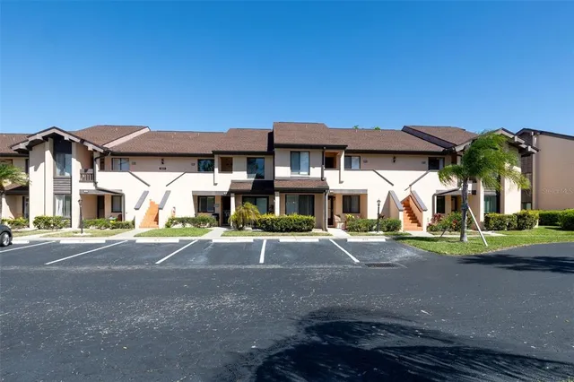 a front view of a house with a yard and parking