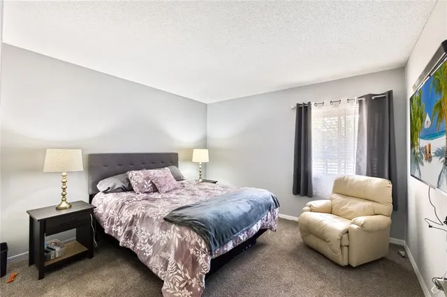 a bedroom with bed and a large window