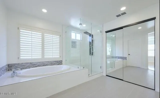 a spacious bathroom with a granite countertop tub shower and sink