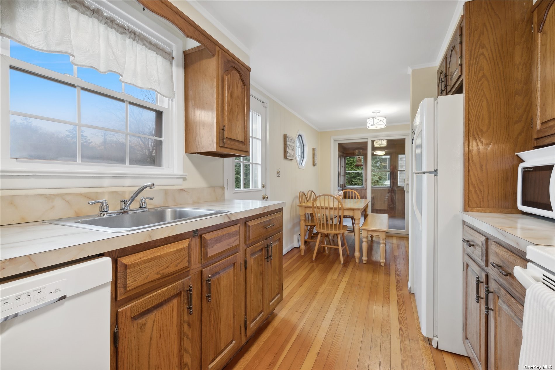 220 Greenport, undefined 00000 - Photo 8 of 21 a kitchen with granite countertop a sink appliances cabinets and wooden floor