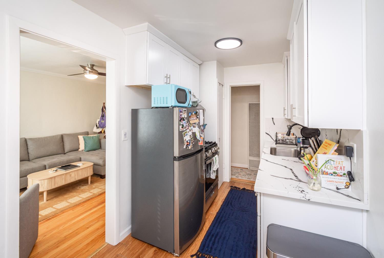 2811 F Street Sacramento, CA 95816 - Photo 10 of 22 a kitchen with stainless steel appliances wooden floor and a refrigerator