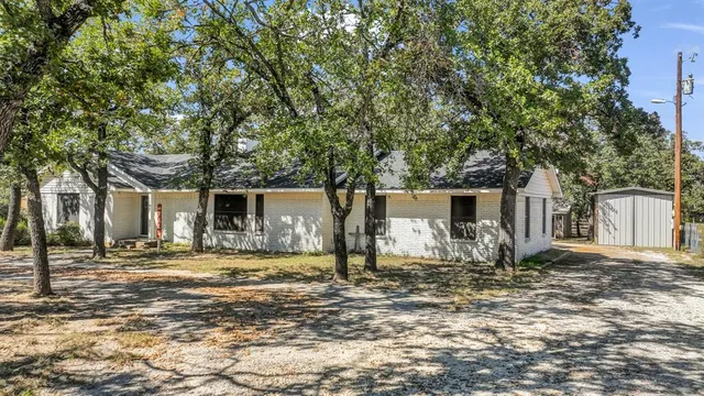 a backyard of a house with yard and large trees