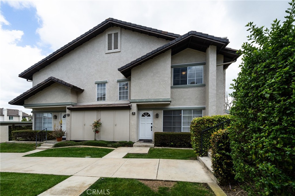 75 Exeter, Unit 33 Irvine, CA 92612 - Photo 1 of 1 a front view of a house with a yard