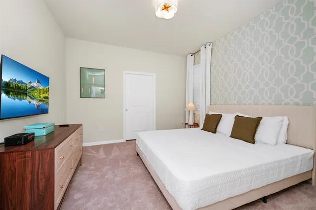 a bedroom with a bed and a flat screen tv