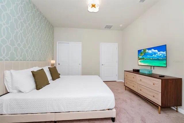 a bedroom with a bed and a flat screen tv