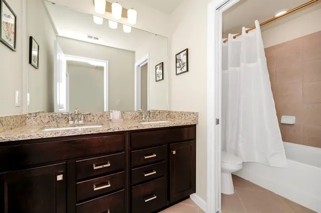 a bathroom with a granite countertop sink a mirror and a bathtub