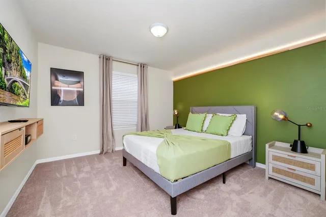 a bedroom with a bed wall painting and a window