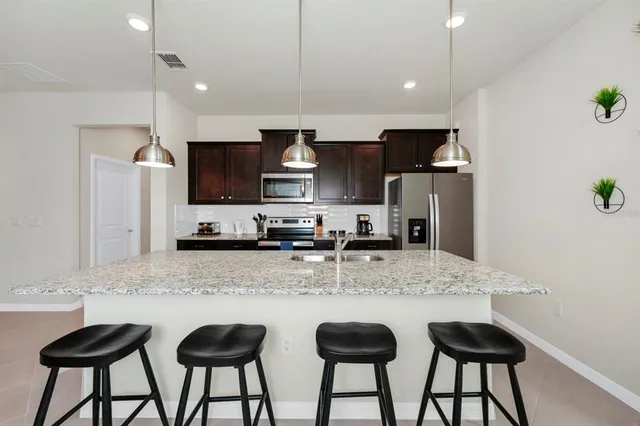 a kitchen with stainless steel appliances granite countertop a sink and a refrigerator