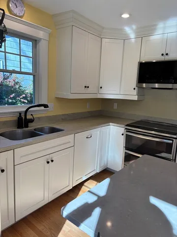 a kitchen with stainless steel appliances white cabinets and a sink