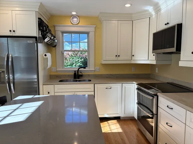 a kitchen with stainless steel appliances granite countertop a stove a sink and a refrigerator