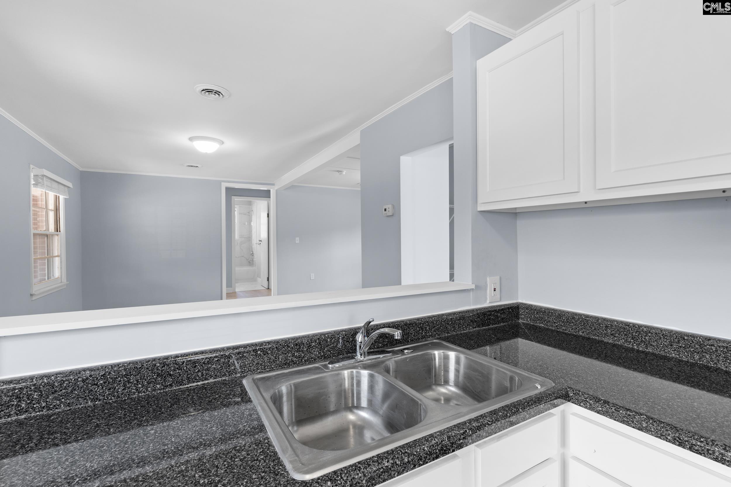 409 Wilkes Road Columbia, SC 29203 - Photo 10 of 34 a kitchen with granite countertop white cabinets and sink
